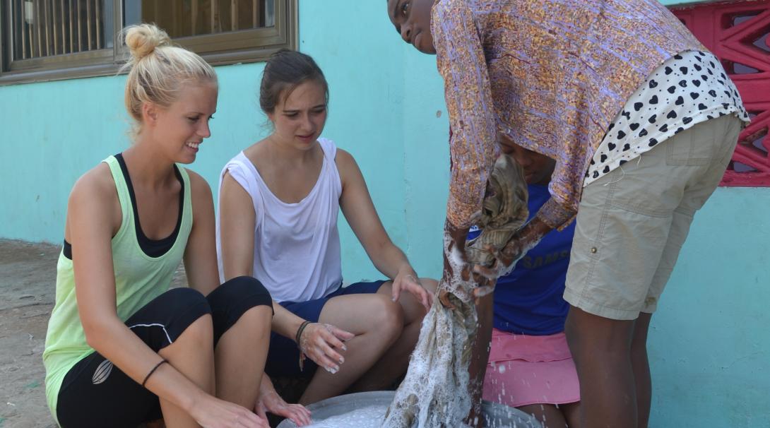 Projects Abroad volunteers get a handwashing activity ready during their childcare volunteer work in Ghana